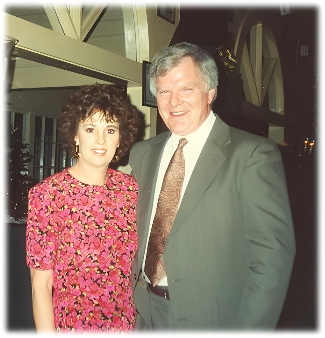 Man and woman posing, formal attire, indoors.