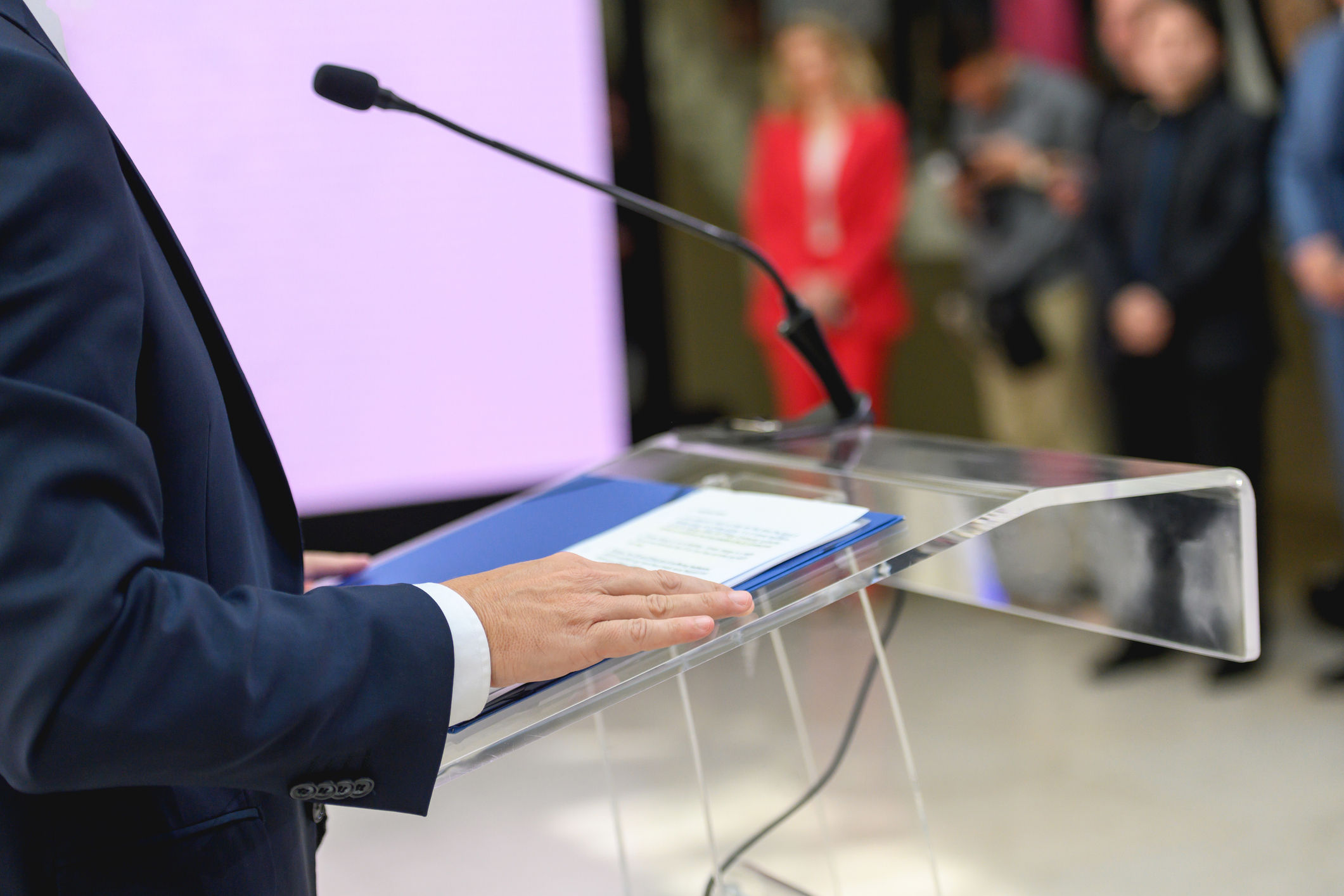 Lectern at a political rally, unrecognizable people