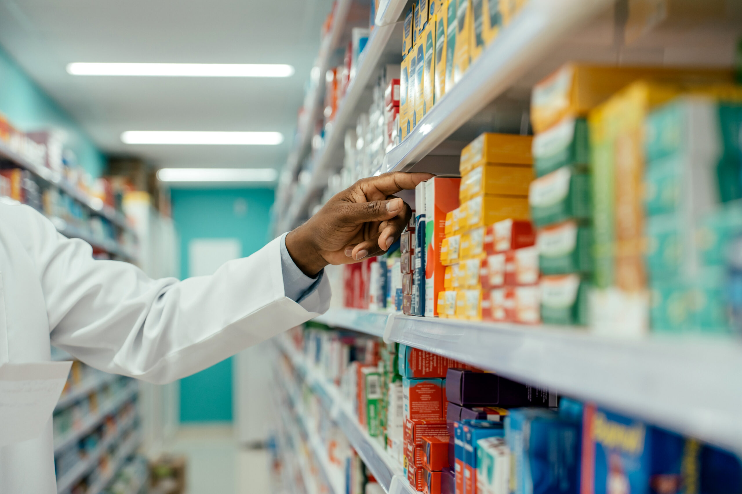 Pharmacist checking medications on the pharmacy shelf.